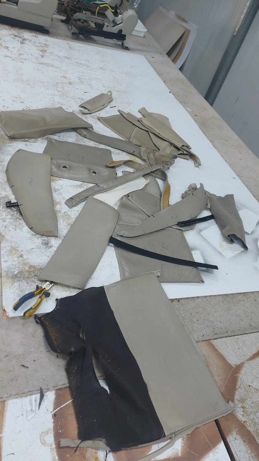 פאנלים מקוריים של מושב הפאג׳רו לאחר פירוק, פרושים וממוספרים על שולחן העבודה