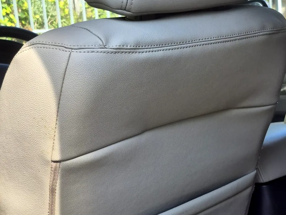 תקריב של משענת ודופן בפאג׳רו לאחר העבודה — עור חלק ותפר צד רציף וישר