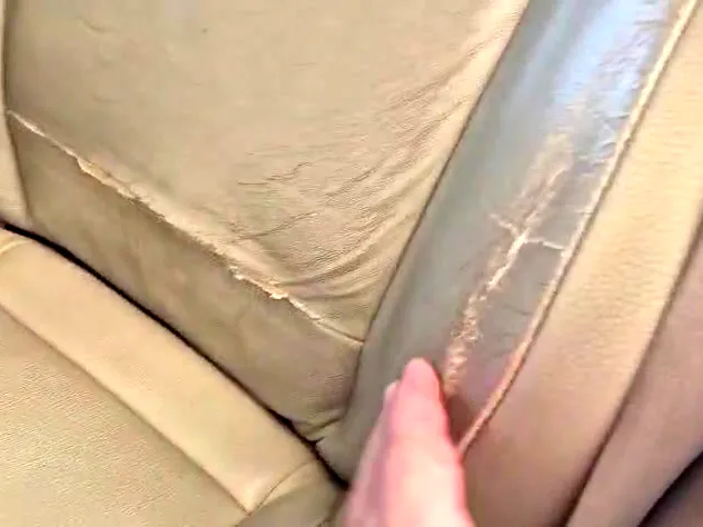 תקריב של דופן מושב בפאג׳רו לפני העבודה — עור סדוק ומקומט ותפר שנפתח